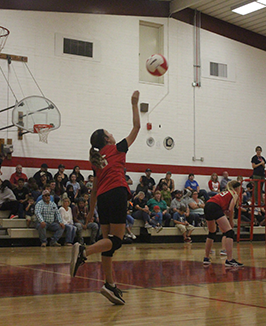 Female volleyball player throwing a volleyball during a game